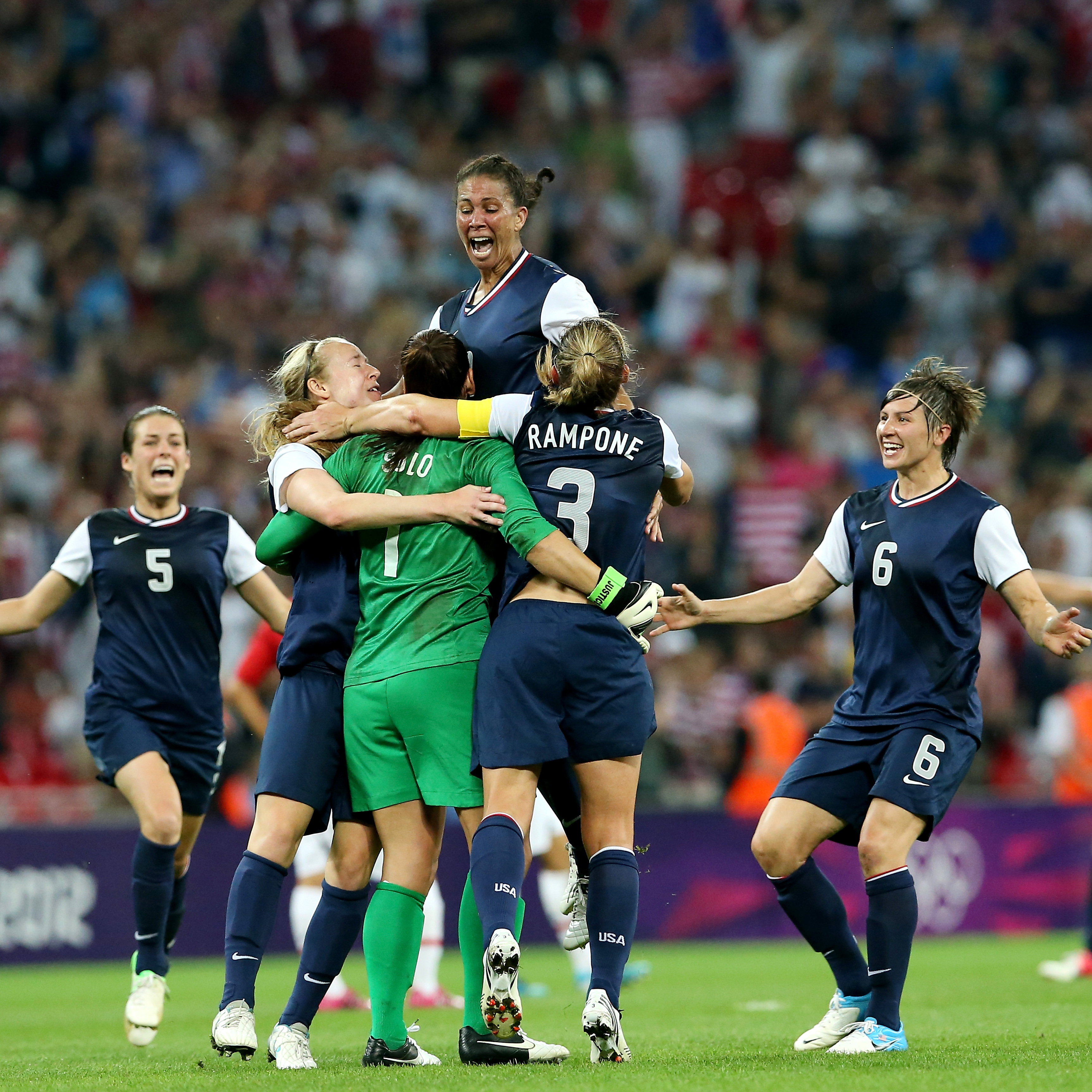 Hope Solo (in green), Shannon Boxx (top), Christie Rampone, Amy LePeilbet (right), and Kelley O'Hara (left) celebrate the U.S. women's soccer team's gold medal, after defeating Japan, 2-1, in London.