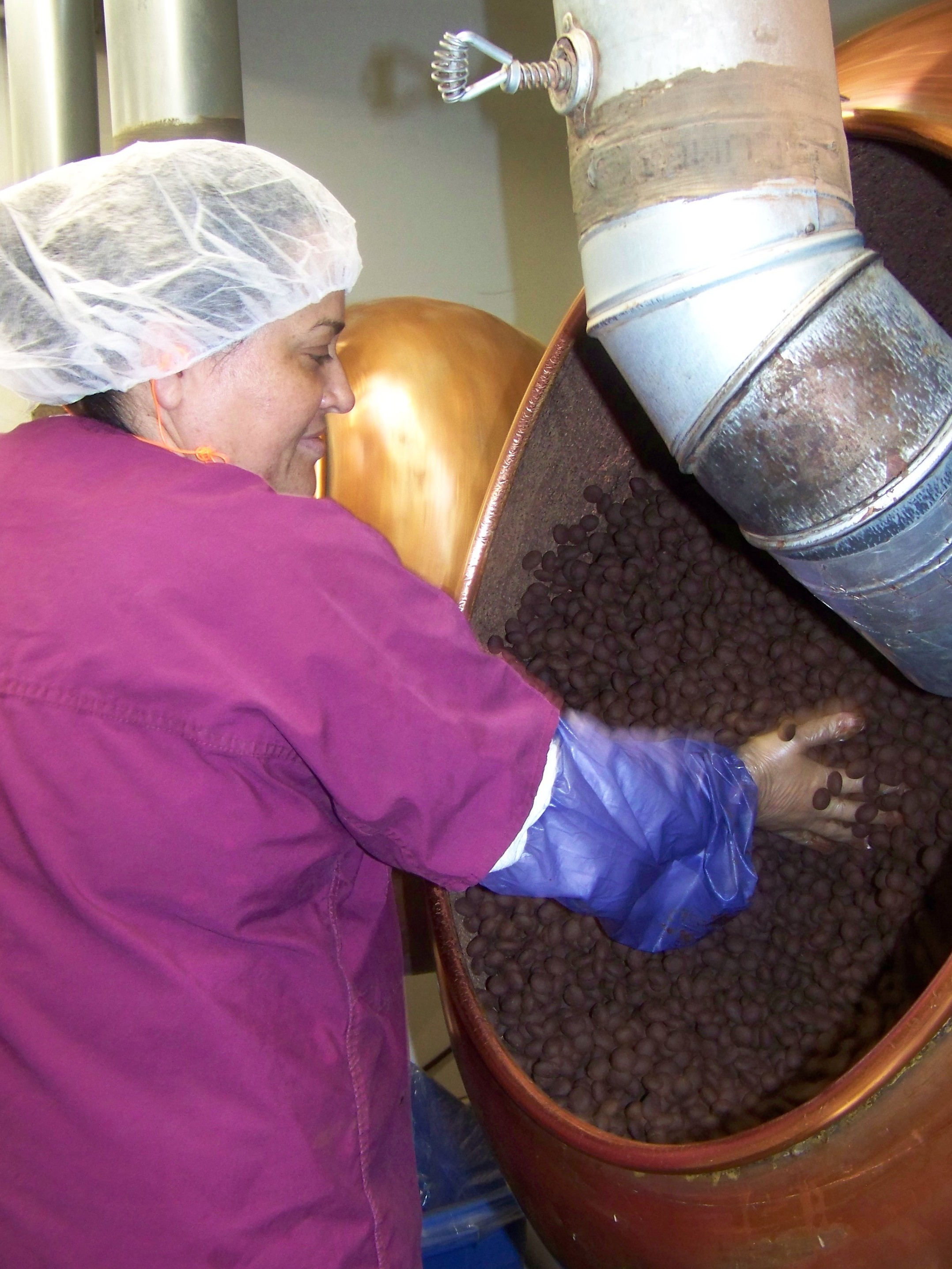 Lupe Lopez ensures a batch of Chukar's Cabernet Cherries are evenly coated with chocolate. (Image credit: Anna King for NPR)