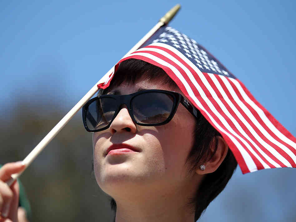 A supporter of Republican Mitt Romney holds an American flag as he speaks during a Memorial Day tribute at the Veterans Museum & Memorial Center in San Diego.