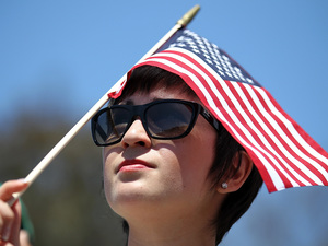 A supporter of Republican Mitt Romney holds an American flag as he speaks during a Memorial Day tribute at the Veterans Museum & Memorial Center in San Diego. A supporter of Republican Mitt Romney holds an American flag as he speaks during a Memorial Day tribute at the Veterans Museum & Memorial Center in San Diego.