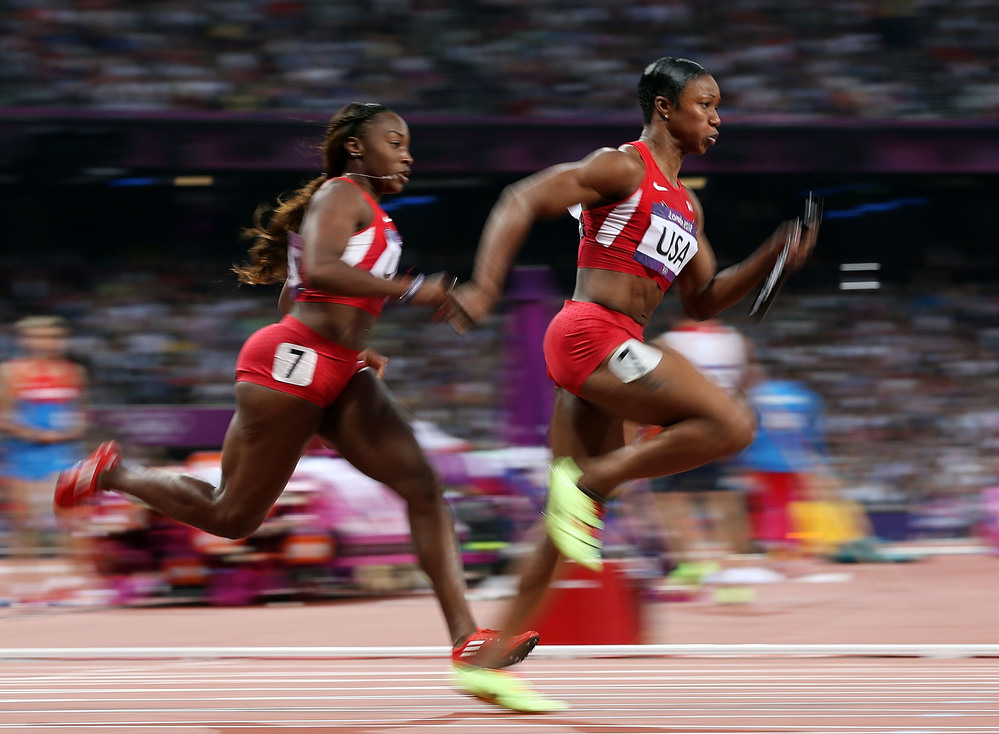 Carmelita Jeter of the United States receives the relay baton fom Bianca Knight of the United States on their way to winning gold in the Women's 4 x 100m Relay Final Friday.