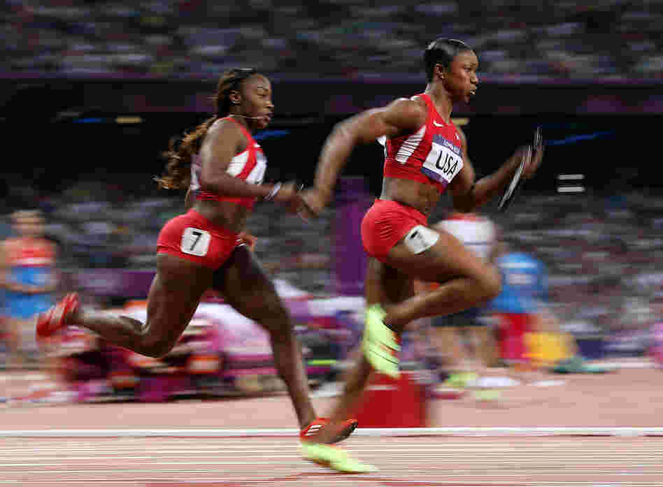 Carmelita Jeter of the United States receives the relay baton fom Bianca Knight of the United States on their way to winning gold in the Women's 4 x 100m Relay Final Friday.
