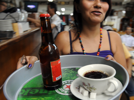 A waitress delivers a coffee and beer in Medellin, Colombia, in this 2010 file photo. Both drinks can trigger acid reflux. A waitress delivers a coffee and beer in Medellin, Colombia, in this 2010 file photo. Both drinks can trigger acid reflux.