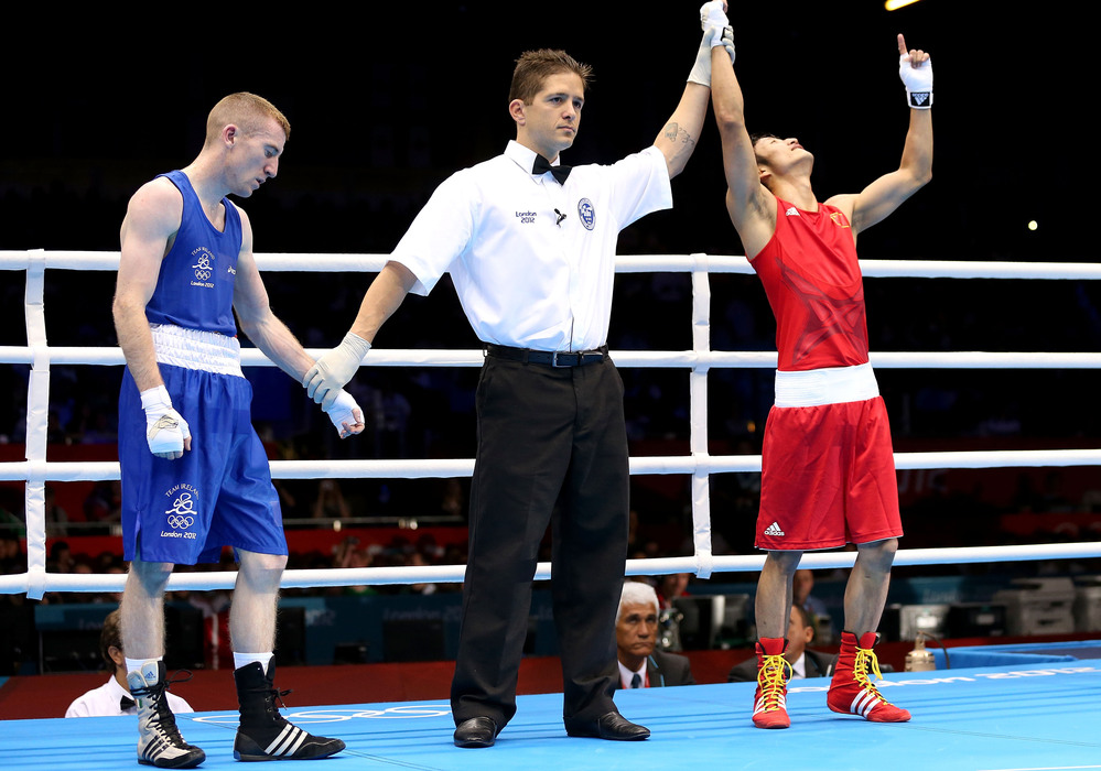 Shiming Zou of China is declared the winner over Paddy Barnes of Ireland during their men's light flyweight boxing semifinal in London. The match was scored a 15-15 tie; Zou won on the number of punches landed.