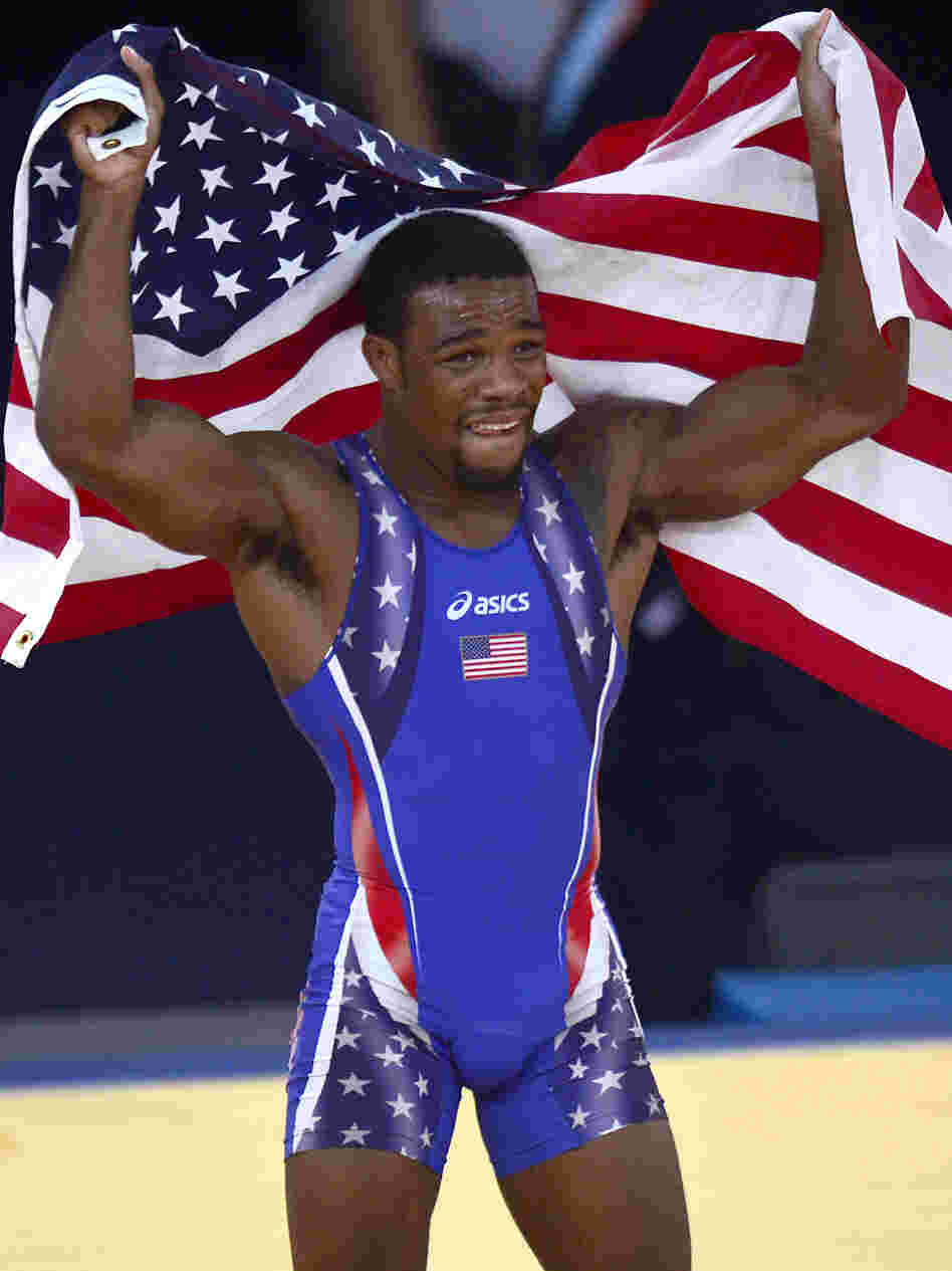 Jordan Burroughs celebrates with the U.S. flag after defeating Iran's Sadegh Saeed Goudarzi in the men's 74kg freestyle gold medal match.