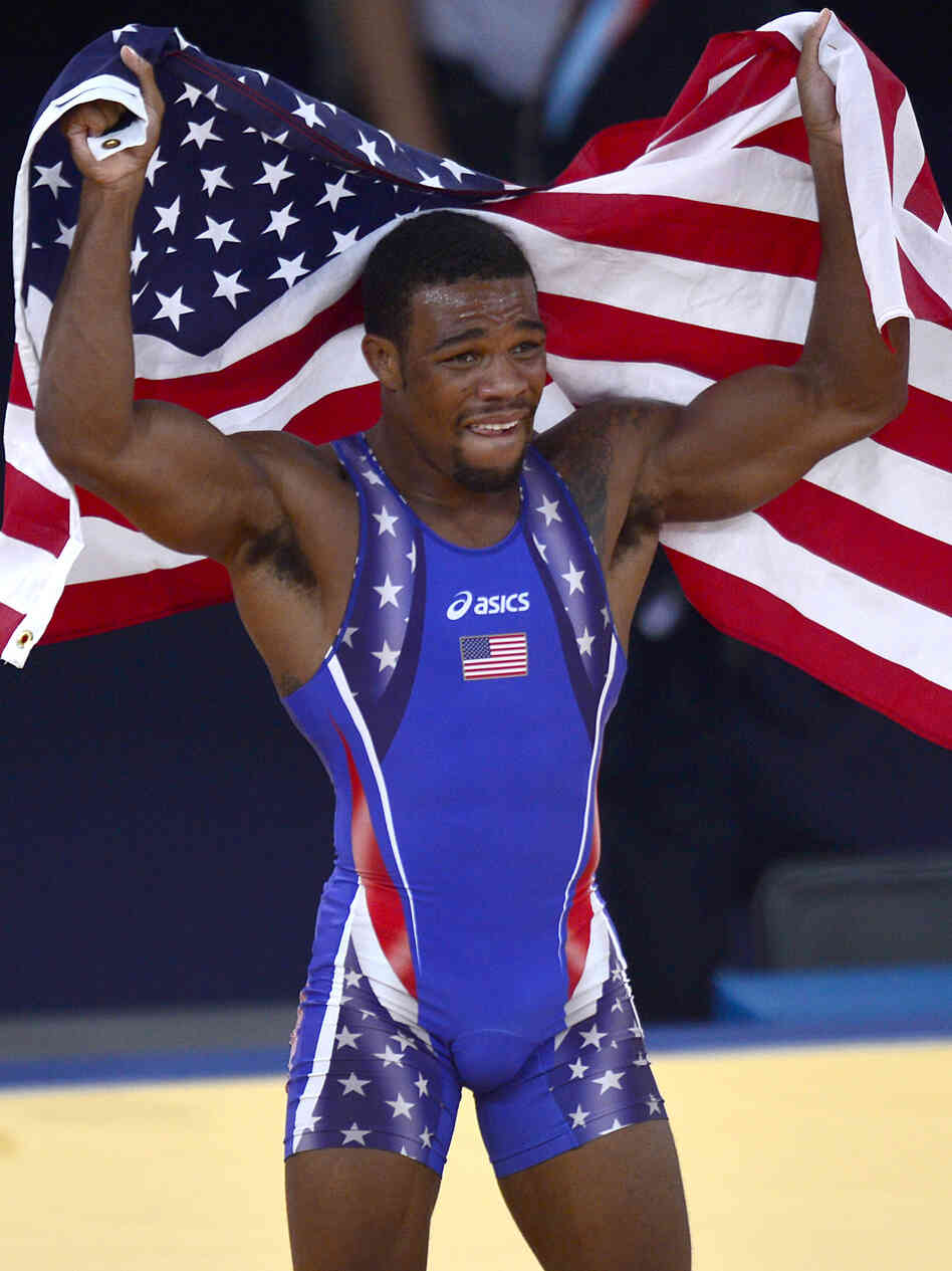 Jordan Burroughs celebrates with the U.S. flag after defeating Iran's Sadegh Saeed Goudarzi in the men's 74kg freestyle gold medal match.