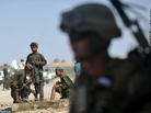 As boys washed their feet in the background, a U.S. Marine stood nearby earlier this summer in Helmand Province, Afghanistan. As boys washed their feet in the background, a U.S. Marine stood nearby earlier this summer in Helmand Province, Afghanistan.
