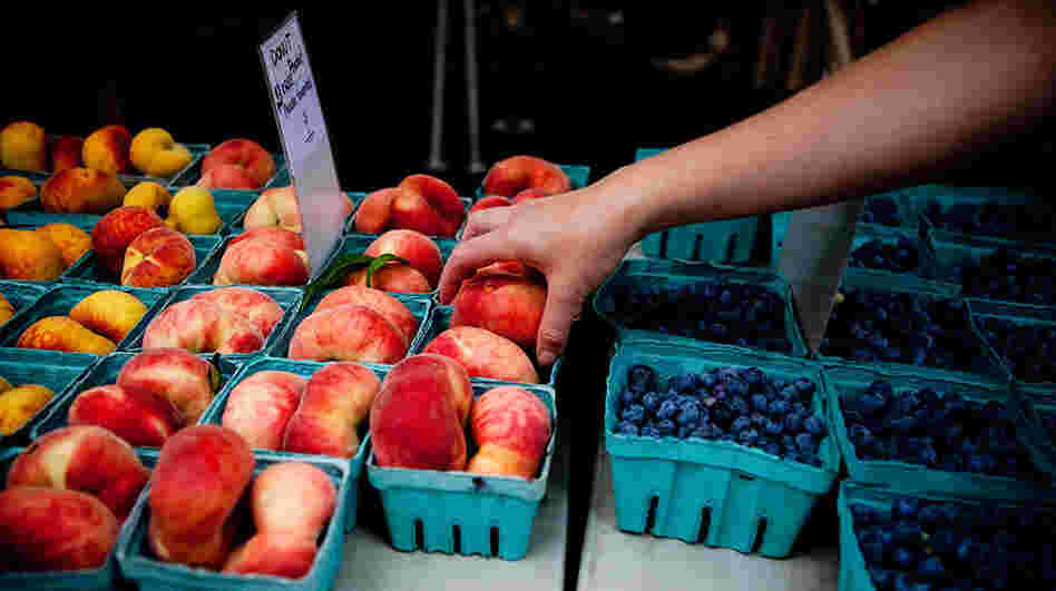 Shopper reaches for donut peaches at the Penn Quarter farmers' market in Washington, D.C. Shopper reaches for donut peaches at the Penn Quarter farmers' market in Washington, D.C.