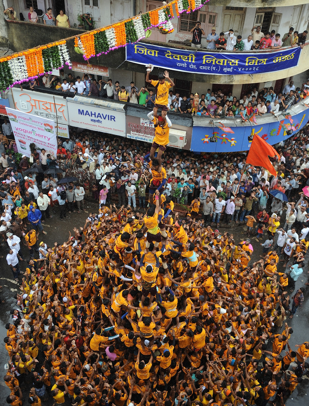 Almost to the top: Men and boys built this human pyramid in Mumbai as part of today's Janmashtami celebration. Their goal — a clay pot — is suspended over the street.