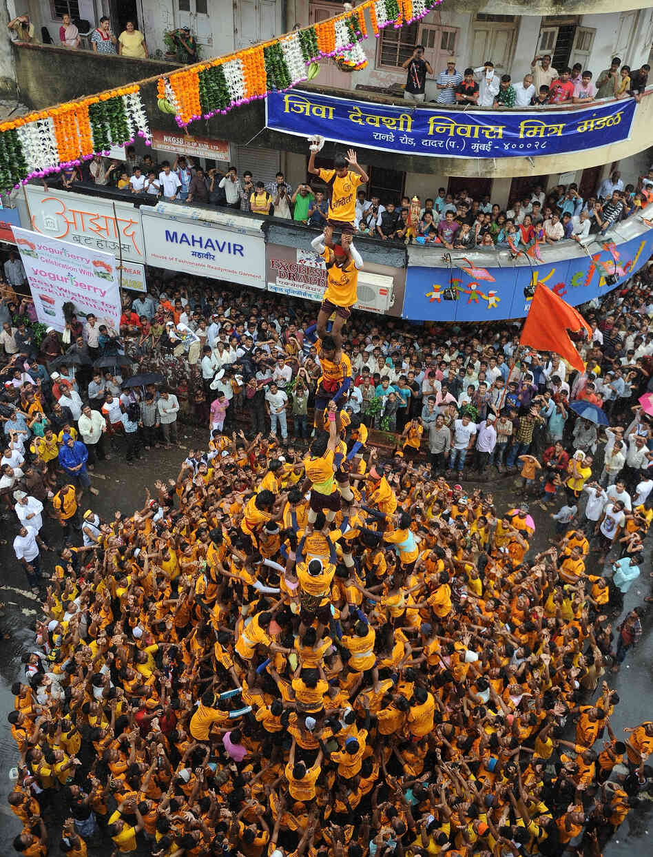 Almost to the top: Men and boys built this human pyramid in Mumbai as part of today's Janmashtami celebration. Their goal — a clay pot — is suspended over the street.
