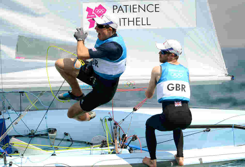 Great Britain's Stuart Bithell leaps off the boat while teammate Luke Patience sails on as they win silver in the men's sailing 470 two-person dinghy medal race in Weymouth, England.