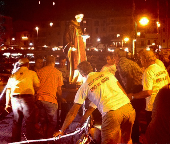 A statue of the patron saint of Porto Santo Stefano, St. Stephen, is removed from a boat for a procession.