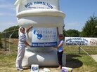 Tim Bair and Theresa Hamilton hoist a Giving the Basics banner. Tim Bair and Theresa Hamilton hoist a Giving the Basics banner.