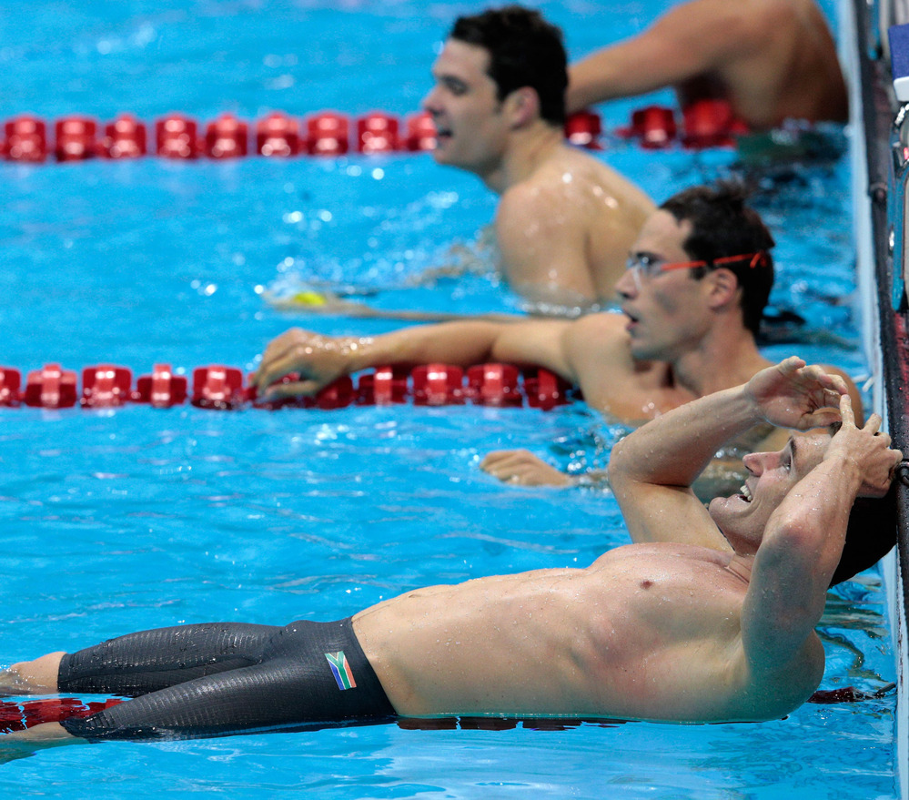 Cameron van der Burgh of South Africa celebrates his gold medal in the men's 100m breaststroke. He later admitted that he took extra dolphin kicks during his swim, a violation of the rules.