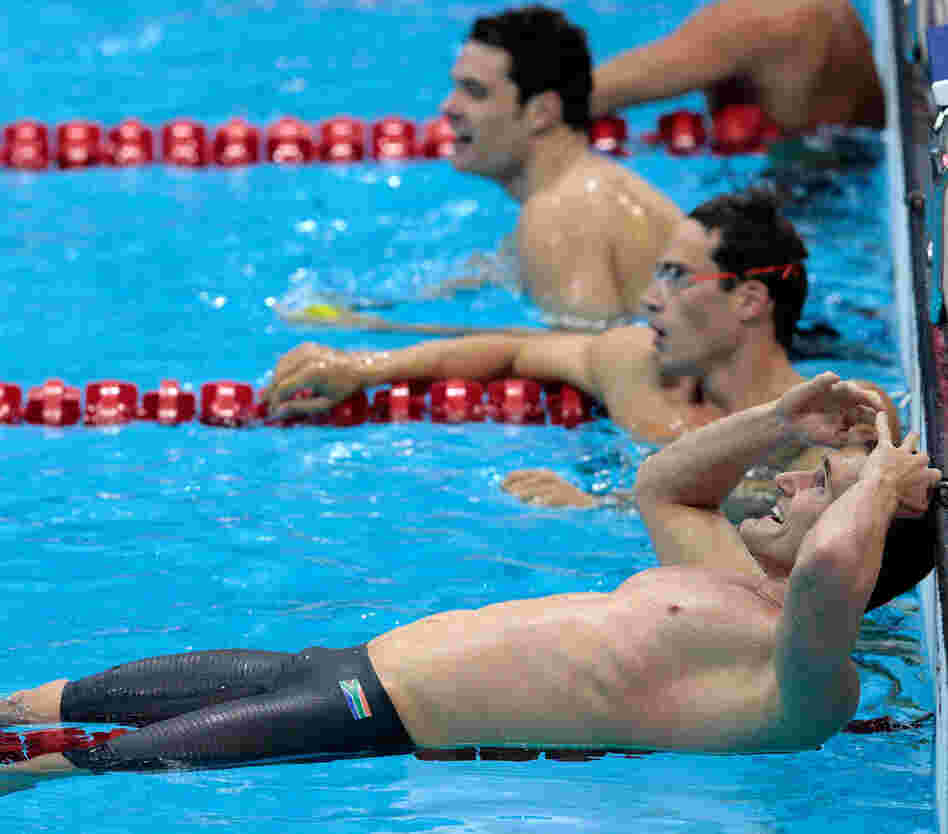 Cameron van der Burgh of South Africa celebrates his gold medal in the men's 100m breaststroke. He later admitted that he took extra dolphin kicks during his swim, a violation of the rules.