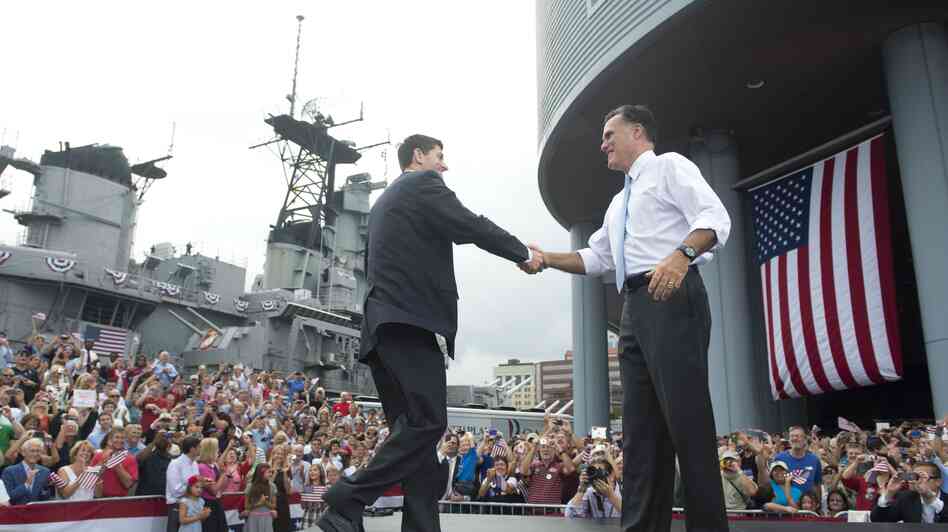 Rep. Paul Ryan of Wisconsin shakes hands with Mitt Romney as he's introduced as Romney's vice presidential running mate Saturday in Norfolk, Va. The USS Wisconsin is in the background.