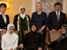 Turkey's Foreign Minister Ahmet Davutoglu (top right) and U.S. Secretary of State Hillary Clinton pose for a photograph with Syrian refugees in Turkey on Saturday. Turkey's Foreign Minister Ahmet Davutoglu (top right) and U.S. Secretary of State Hillary Clinton pose for a photograph with Syrian refugees in Turkey on Saturday.