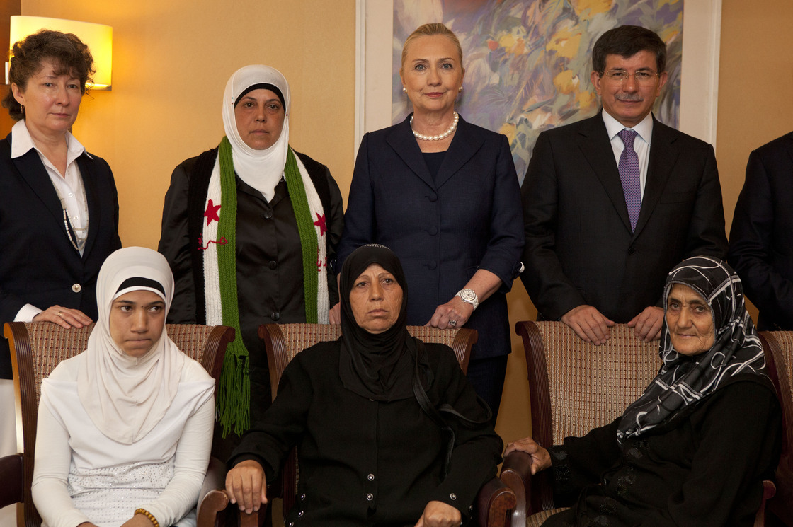 Turkey's Foreign Minister Ahmet Davutoglu (top right) and U.S. Secretary of State Hillary Clinton pose for a photograph with Syrian refugees in Turkey on Saturday.