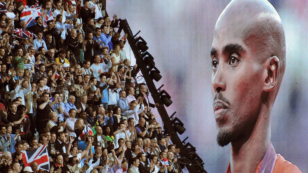 British runner Mo Farah is cheered as he appears on a giant screen at Olympic Stadium, accepting his gold medal for the 10,000 meters. Farah has become a celebrity in Britain since his win.