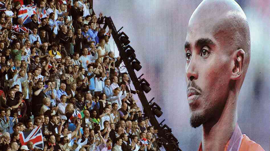 British runner Mo Farah is cheered as he appears on a giant screen at Olympic Stadium, accepting his gold medal for the 10,000 meters. Farah has become a celebrity in Britain since his win.