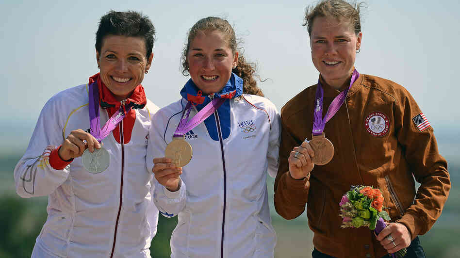 France's gold medalist Julie Bresset (center), Germany's silver medalist Sabine Spitz (left) and U.S. bronze medalist Georgia Gould stand on the podium of the women's cycling cross-country mountain bike event in Benfleet, England.