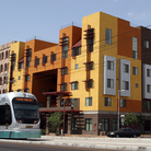 A Metro Light Rail train rolls by the Devine Legacy apartment building along Central Avenue in Phoenix. The energy-efficient complex includes 65 "urban style" apartments.