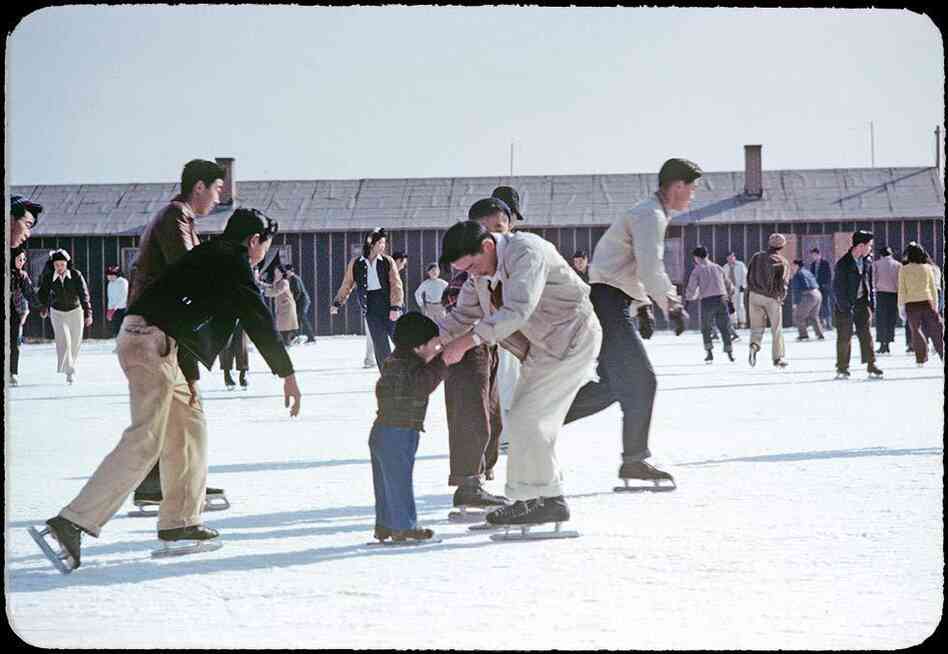 Photographer Bill Manbo's son Billy (center) gets a lesson in ice skating. Internees at Heart Mountain used fire hoses to create skating rinks around the camp during winter months.