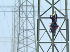 A worker on a newly constructed transmission tower near Buetzow, Germany, earlier this month. The German government plans to shut down nuclear power plants and is seeking to replace that production with power from renewable energy sources, especially wind turbines and solar parks. New power transmission lines will be needed. A worker on a newly constructed transmission tower near Buetzow, Germany, earlier this month. The German government plans to shut down nuclear power plants and is seeking to replace that production with power from renewable energy sources, especially wind turbines and solar parks. New power transmission lines will be needed.