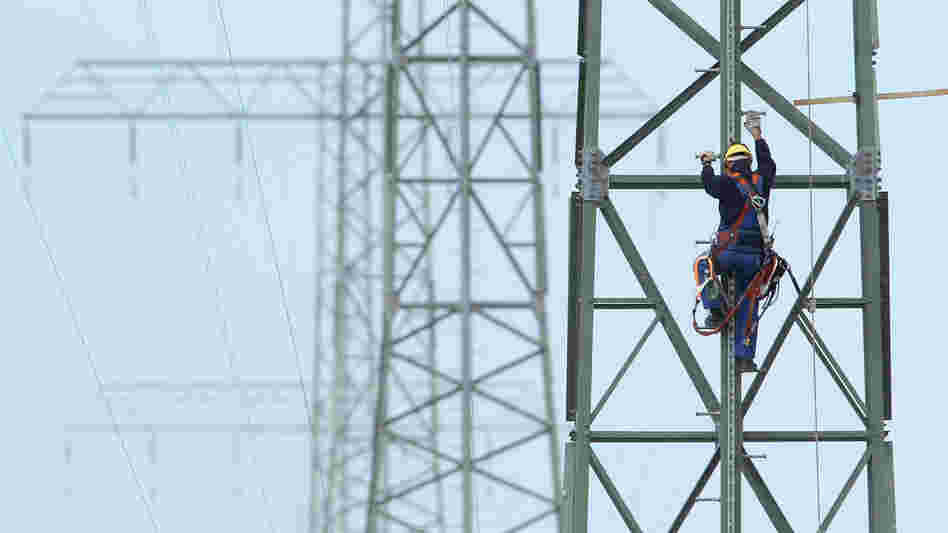 A worker on a newly constructed transmission tower near Buetzow, Germany, earlier this month. The German government plans to shut down nuclear power plants and is seeking to replace that production with power from renewable energy sources, especially wind turbines and solar parks. New power transmission lines will be needed. A worker on a newly constructed transmission tower near Buetzow, Germany, earlier this month. The German government plans to shut down nuclear power plants and is seeking to replace that production with power from renewable energy sources, especially wind turbines and solar parks. New power transmission lines will be needed.