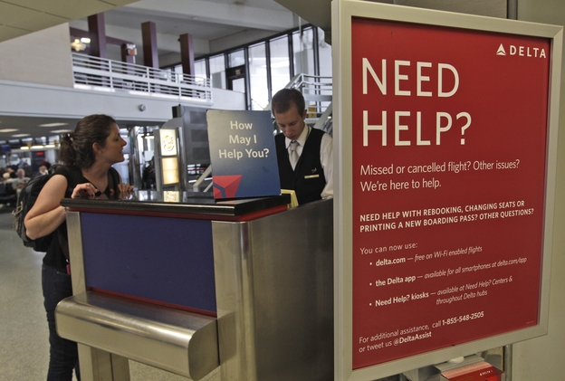 A Delta Airlines agent assists a woman at JFK International Airport in New York.