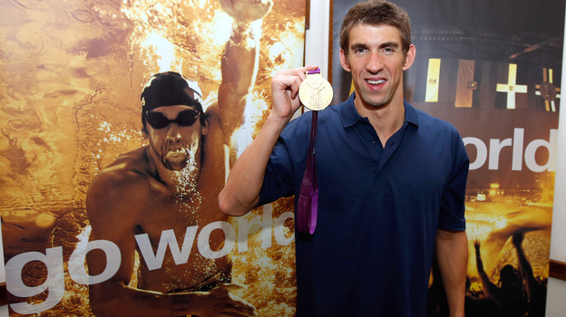 Michael Phelps poses with one of his record 22 Olympic medals after a press conference presented by Visa in London. Now that he's retired, Phelps hopes to see some of the world's cities that he's competed in.