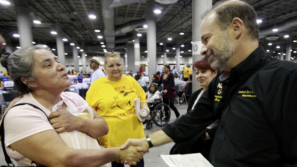 Sara Millan (left) thanks Neighborhood Assistance Corporation of America CEO Bruce Marks after NACA was able to reduce her family's mortgage during an event in Los Angeles in September 2010.