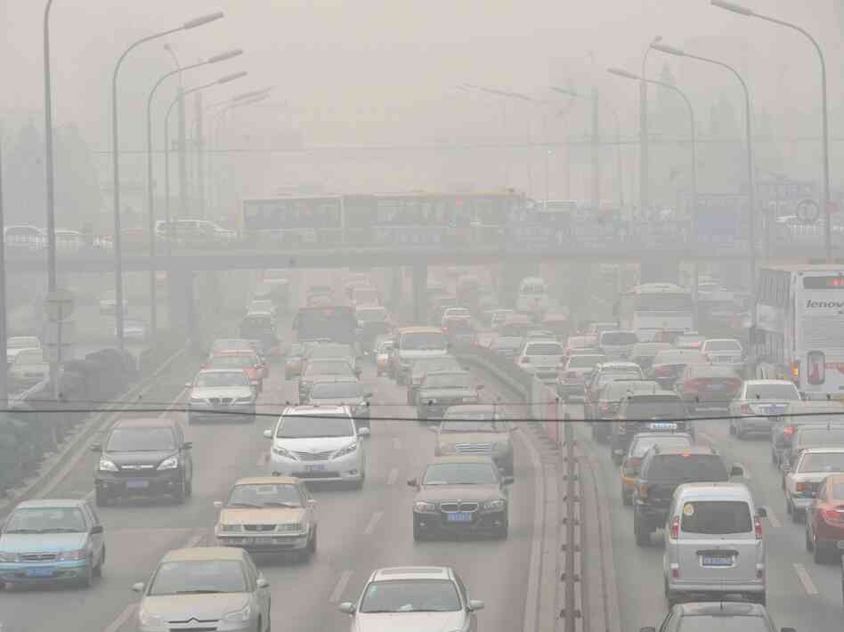 Vehicles make their way along a road on a smoggy day in Beijing on January 18, 2011. Beijing's government bowed to a vocal online campaign for a change in the way air quality is measured in the Chinese capital, one of the world's most polluted cities.