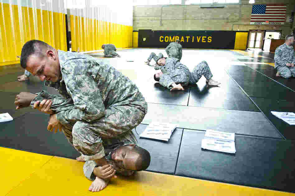 Staff Sgt. Ronald Sherwood practices a maneuver on Sgt. 1st Class Darwin Scriber at the U.S. Army Combatives School at Fort Benning, Ga. The school trains instructors who will teach recruits hand-to-hand combat. Most of the student instructors have fought in Iraq and Afghanistan.