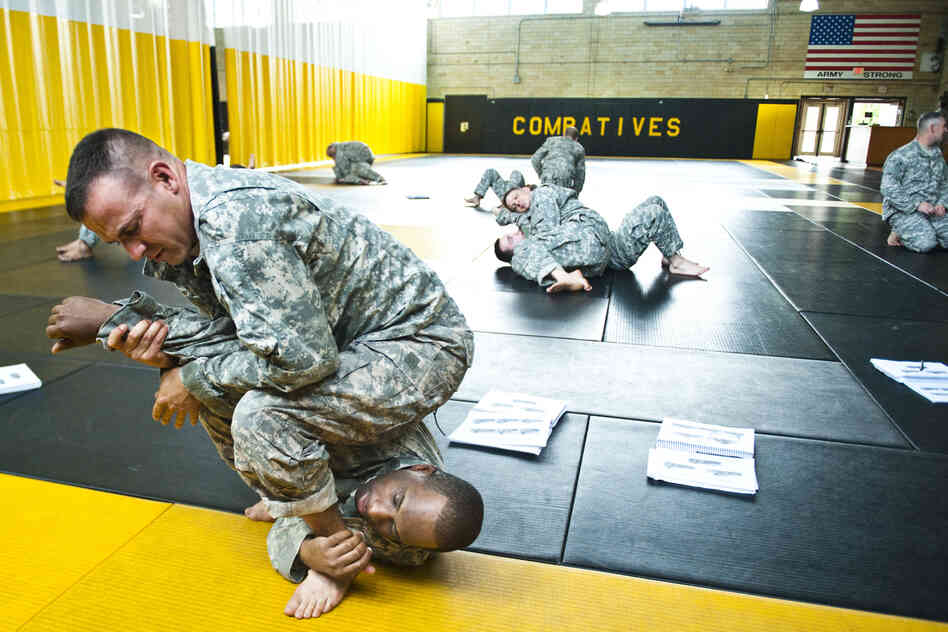 Staff Sgt. Ronald Sherwood practices a maneuver on Sgt. 1st Class Darwin Scriber at the U.S. Army Combatives School at Fort Benning, Ga. The school trains instructors who will teach recruits hand-to-hand combat. Most of the student instructors have fought in Iraq and Afghanistan.