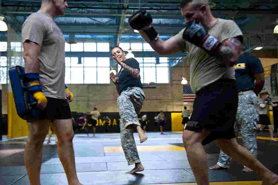 U.S. Army combatives instructor Sgt. Teddra Rodriguez (center) demonstrates a move to two students.