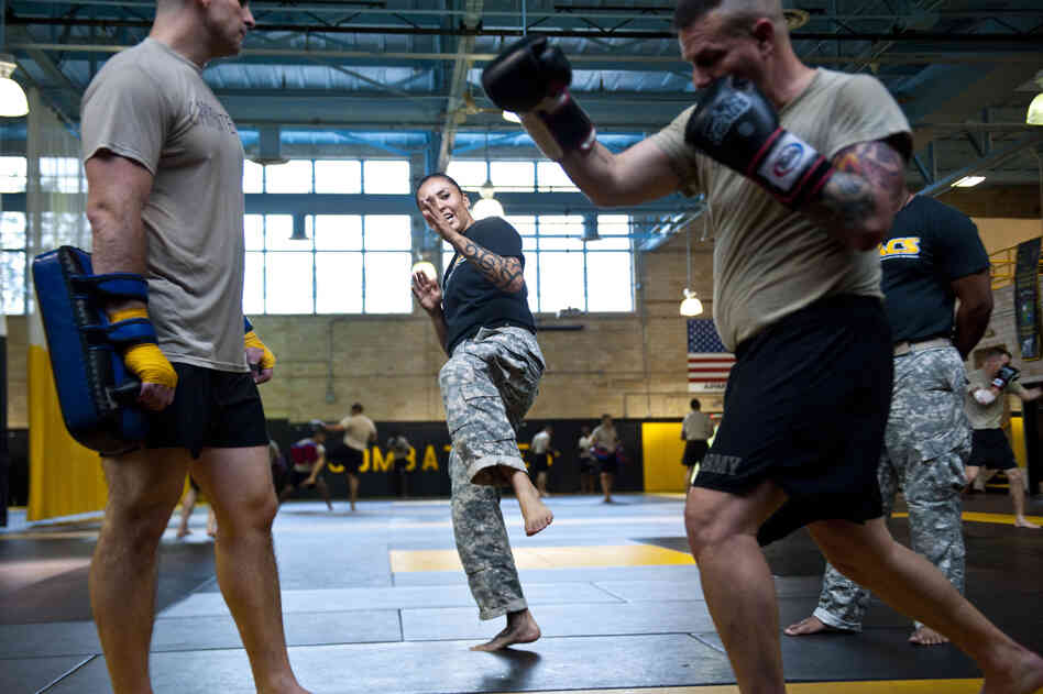 U.S. Army combatives instructor Sgt. Teddra Rodriguez (center) demonstrates a move to two students.