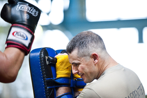 Maj. Christopher Carpenter takes a series of kicks and punches from a sparring partner. The soldiers take turns holding pads and practicing kicking and punching combos that will help them in close combat situations.
