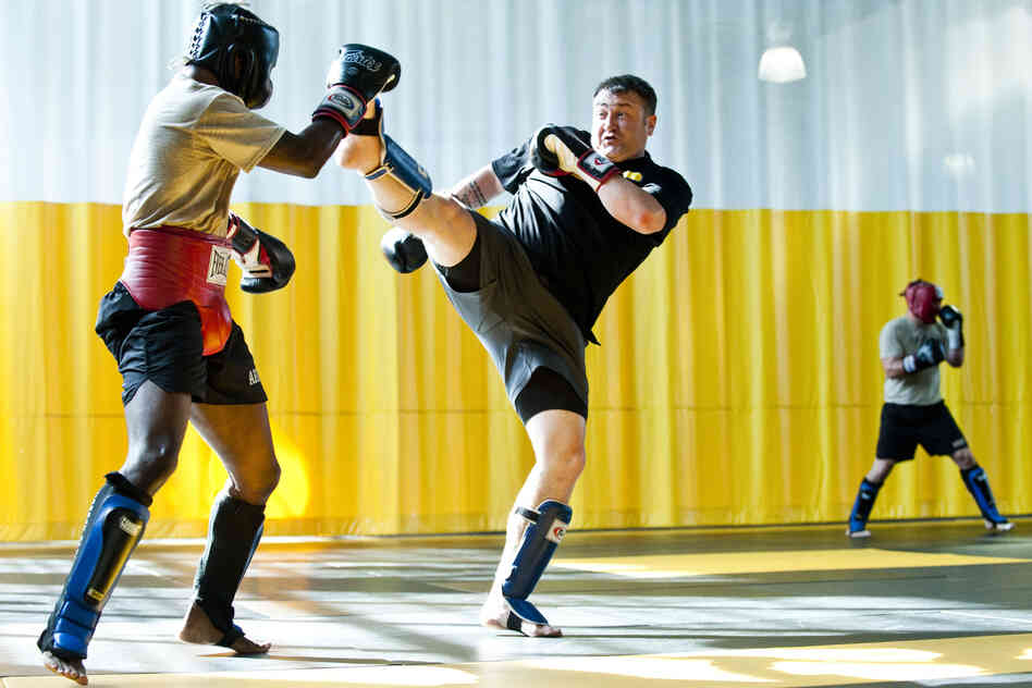 Sgt. 1st Class Kevin Rice, a master trainer at the U.S. Army Combatives School, drives back his partner with a high kick during a sparring session.