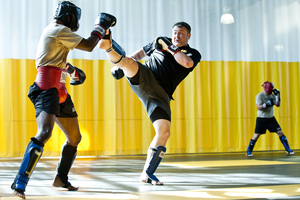 Sgt. 1st Class Kevin Rice, a master trainer at the U.S. Army Combatives School, drives back his partner with a high kick during a sparring session.