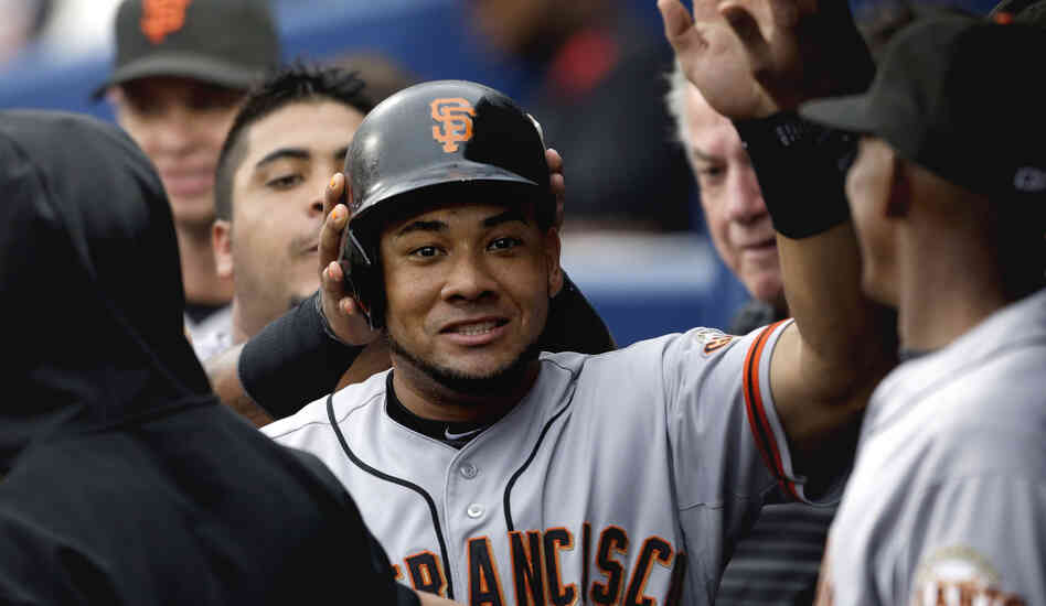 San Francisco Giants' Melky Cabrera high-fives teammates after scoring off a single by teammate Buster Posey in the third inning of a baseball game against the Atlanta Braves in July.