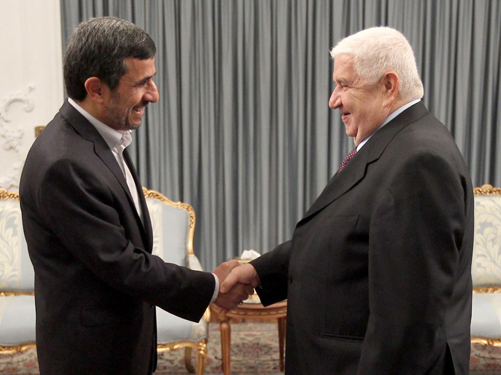 Iranian President Mahmoud Ahmadinejad (left) greets Syrian Foreign Minister Walid al-Muallem in the presidential palace in Tehran on July 29, in this official handout photo. The war in Syria threatens Iran's only ally in the Arab world.