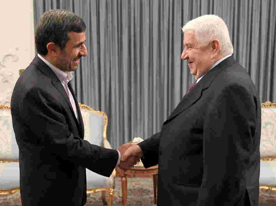 Iranian President Mahmoud Ahmadinejad (left) greets Syrian Foreign Minister Walid al-Muallem in the presidential palace in Tehran on July 29, in this official handout photo. The war in Syria threatens Iran's only ally in the Arab world.