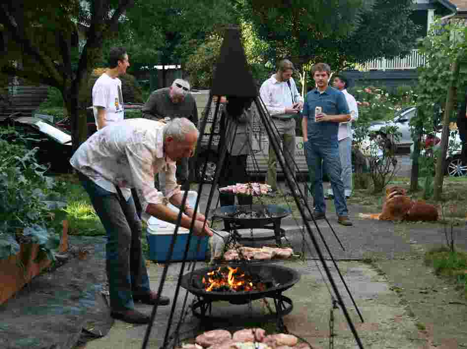 Ewald Mosel keeps the schwenkers swinging to ensure that the pork cooks evenly, while hungry guests look on.