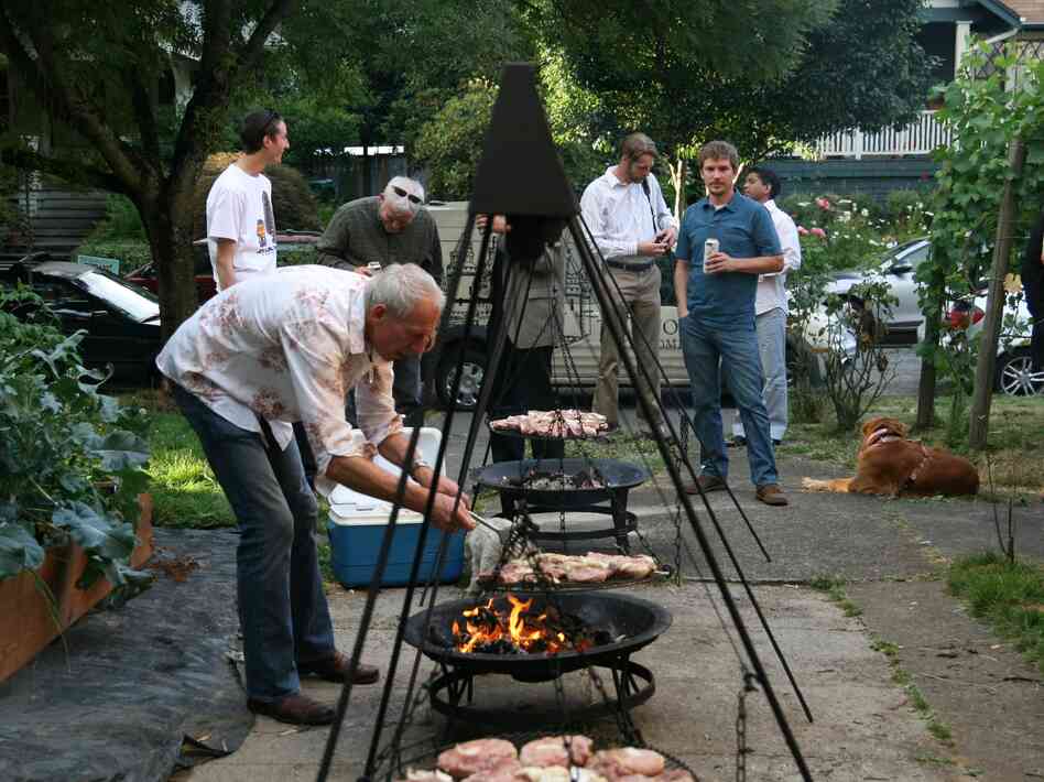 Ewald Mosel keeps the schwenkers swinging to ensure that the pork cooks evenly, while hungry guests look on.