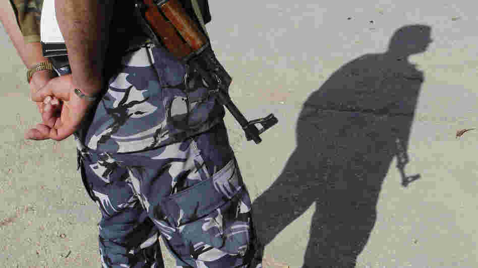 A Syrian soldier casts a shadow as he stands in the northwest city of Idlib in May. Growing numbers of Syrian soldiers are defecting and joining the rebels. A Syrian soldier casts a shadow as he stands in the northwest city of Idlib in May. Growing numbers of Syrian soldiers are defecting and joining the rebels.