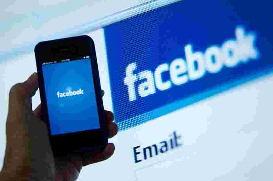An illustration of an Apple iPhone displaying the Facebook app's splash screen in front of the login page.