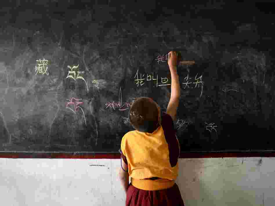 A lama student writes Chinese characters on a blackboard during a class on November 1, 2007 in Dari County of Guoluo Prefecture, Qinghai Province, northwest China.
