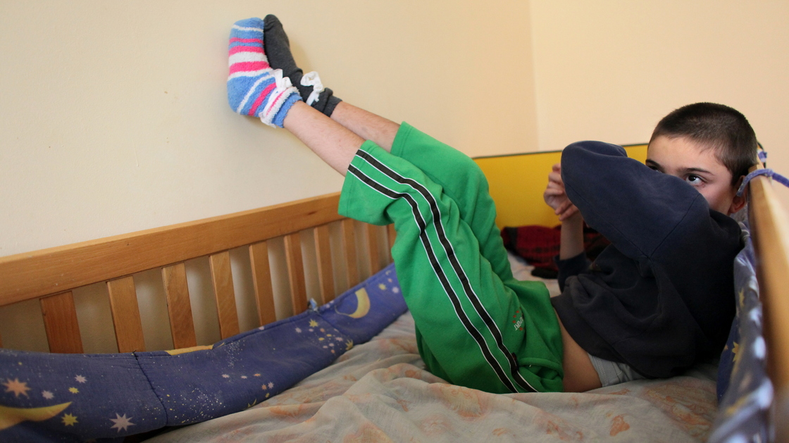 A disabled and orphaned Romanian child in his bed at the Targu Jiu orphanage in southwestern Romania in 2009. Romania has, in general, improved conditions in orphanages that provoked outrage when they were exposed internationally nearly a quarter-century ago. However, some 70,000 kids are still in the care of the state.