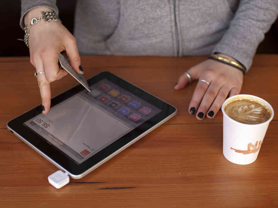 A barista processes a customer's payment using Square, a device that turns a mobile device into a card swiper. More businesses are using the devices to simplify credit card payments. Others are embracing technology that allows consumers to pay with their cellphones.
